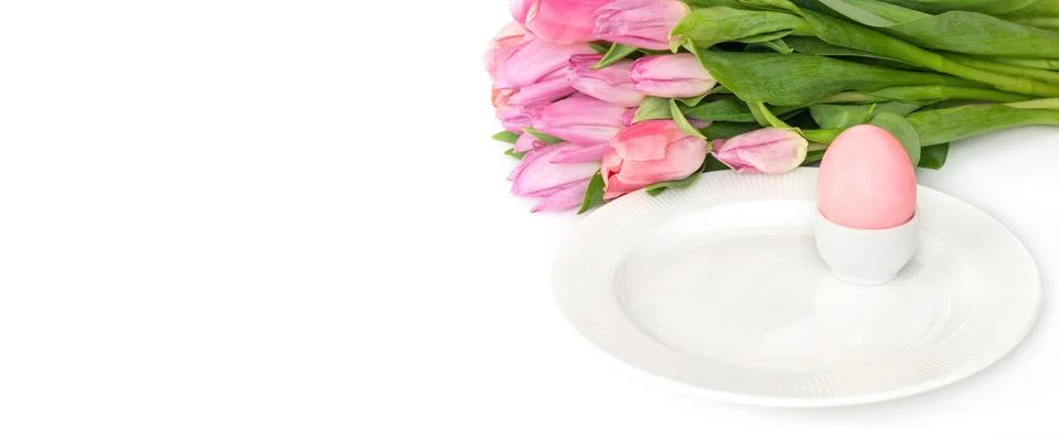 Easter table setting with spring flowers tulips and a pink Easter egg  Stock Photos