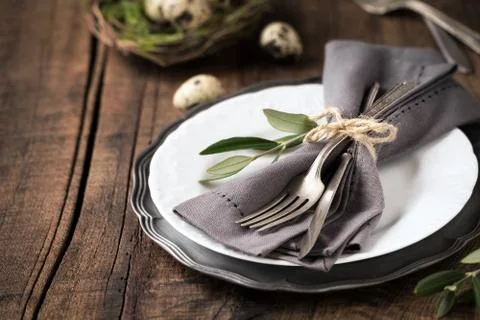 Easter table setting with vintage silverware with an olive branch on a plate Stock Photos