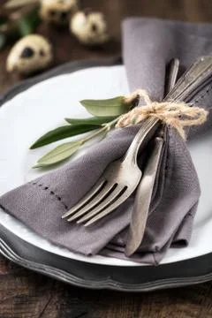 Easter table setting with vintage silverware with an olive branch on a plate Stock Photos
