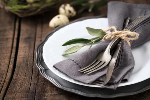 Easter table setting with vintage silverware with an olive branch on a plate Stock Photos
