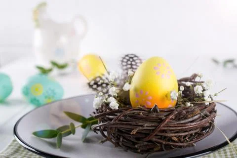 Easter table setting with  white plate, textile napkin yellow decorative eggs Foto stock
