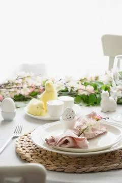 Easter table setting with yellow chick, fresh flowers and eggs. Close up. Stock Photos