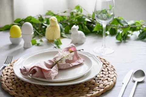 Easter table setting with yellow chick,decorations, fresh flowers and eggs. Stock Photos