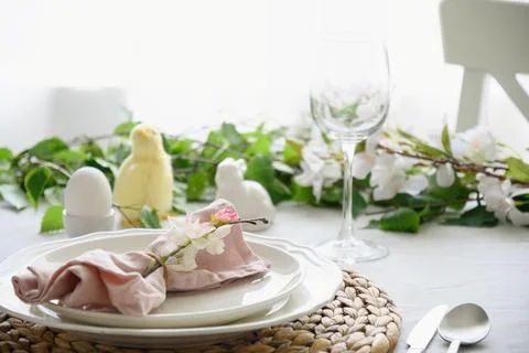 Easter table setting with yellow chick,decorations, fresh flowers and eggs. Stock Photos