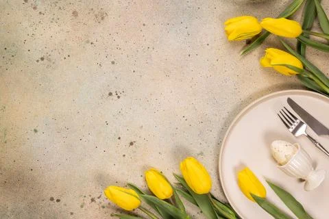 Easter table setting with yellow tulips and an egg Stock Photos