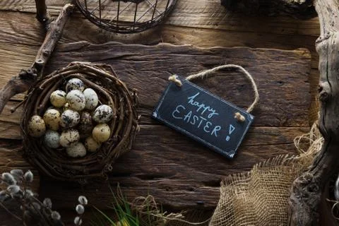 Easter table setting.Quail eggs in nest. Spring table. Happy Easter text on p Stock Photos
