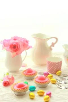 Easter table with sweet eggs, pink roses and fresh cakes Stock Photos