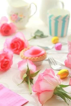 Easter table with sweet eggs, pink roses and fresh cakes Stock Photos