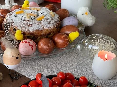 Easter table with traditional cake, dyed eggs, and festive decorations Stock Photos