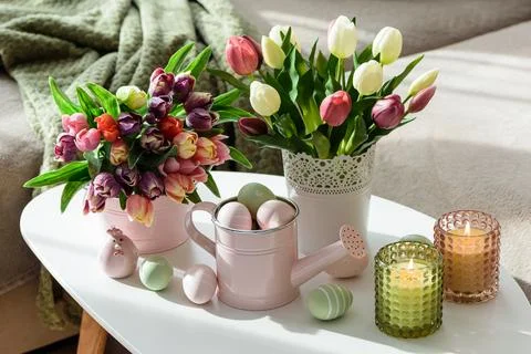 Easter Table with Tulip Bouquets, Eggs, Candles and Festive Decor. Cozy Spr.. Stock Photos