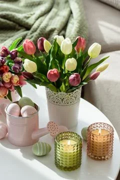 Easter Table with Tulip Bouquets, Eggs, Candles and Festive Decor. Cozy Spr.. Stock Photos