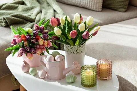 Easter Table with Tulip Bouquets, Eggs, Candles and Festive Decor. Cozy Spr.. Stock Photos