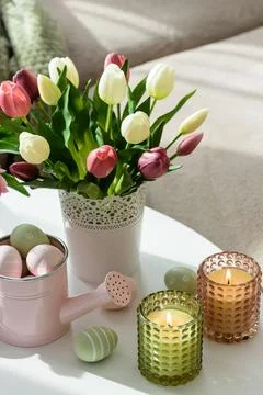 Easter Table with Tulip Bouquets, Eggs, Candles and Festive Decor. Cozy Spr.. Stock Photos