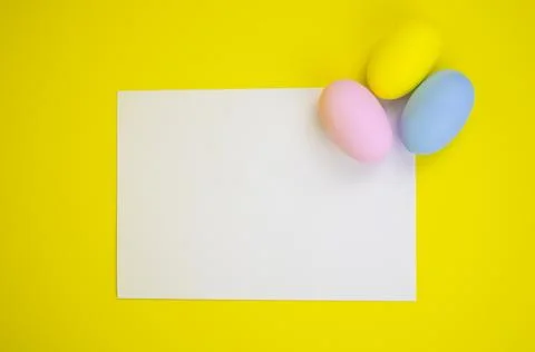 Easter template. White sheet with copy space on a yellow background and eggs Stock Photos