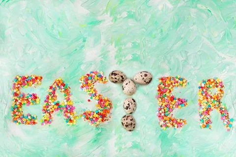 Easter text on a green background with brush strokes with quail eggs letter.. Stock Photos