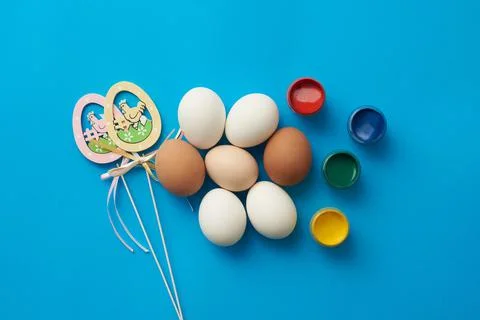 Easter theme template with chicken eggs and paints on a blue background Stock-Fotos