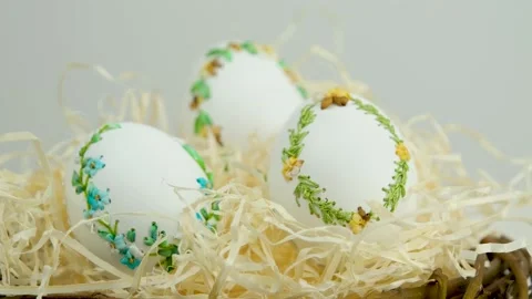 Easter three beautiful embroidered eggs with eggshell ribbons in a nest with Vidéo 233970116