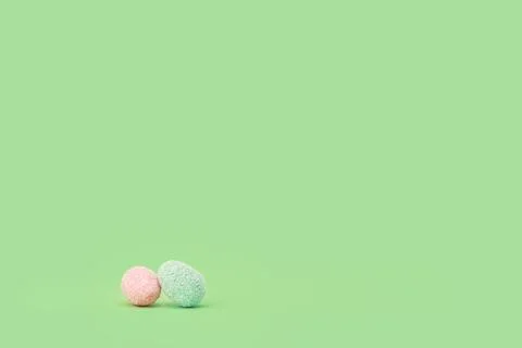 Easter tiny eggs sweets on green background. Stock Photos