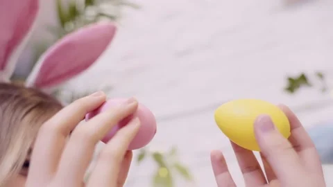 Easter traditions. Two teens with bunny ears playing with colorful eggs Stock Footage 236341717
