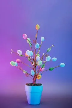 Easter tree decor in blue pot with colorful eggs in neon colors light. Purple Stock Photos