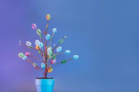 Easter tree decor in blue pot with colorful eggs in blue neon colors. Purple and Stock Photos
