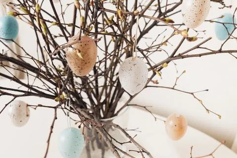 Easter tree decorated white and beige eggs in vase on white table. Close up. Stock Photos