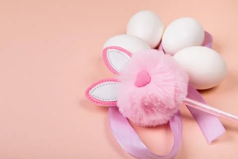 Easter. White eggs with an artificial rabbit on a uniform background. Stock Photos