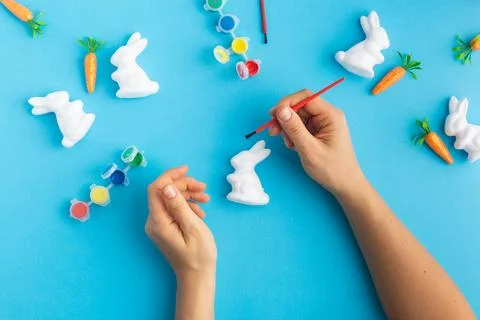Easter white rabbits ready to paint carrots concept hands Stock Photos