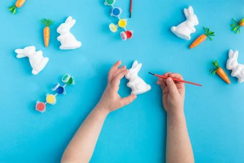Easter white rabbits ready to paint carrots concept hands Stock Photos
