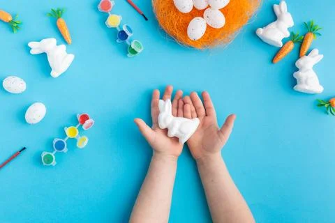 Easter white rabbits ready to paint carrots concept hands Stock Photos