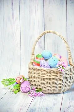 Easter, wicker basket with Easter eggs on a light wooden background Stock Photos