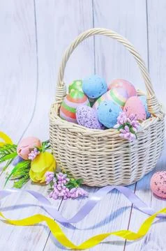 Easter, wicker basket with Easter eggs on a light wooden background Stock Photos
