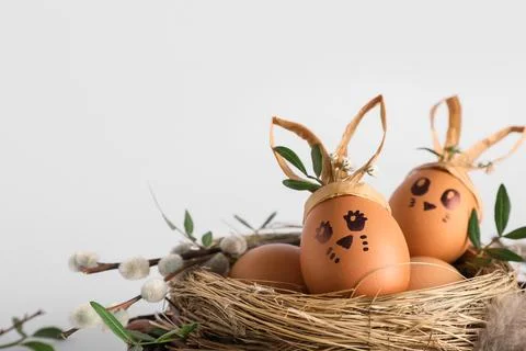 Easter wreath with nest of creative eggs and pussy willow branches on white b Stock Photos