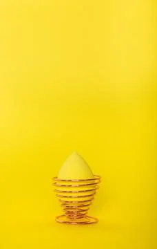Easter yellow egg on the yellow background. Space for text. Beauty blender Foto stock