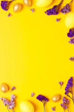 Easter yellow eggs with purple flowers on yellow background. Flat lay, copy s Stock Photos