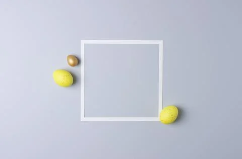 Easter yellow eggs with white frame on white background. Flat lay, copy space Stock Photos