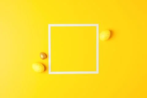 Easter yellow eggs on a yellow background with white square. Flat lay, copy s Stock Photos