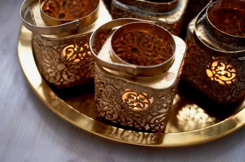 Eastern candlesticks with patterns in gold leaf with a burning candle.stand on a Stock Photos