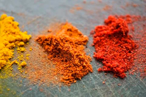 Eastern condiments scattered on a table at home. Turmeric and pe Stock Photos