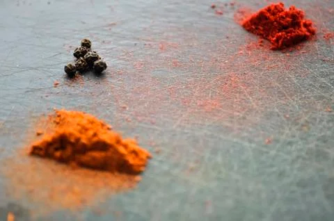 Eastern condiments scattered on a table at home. Turmeric and pe Stock Photos
