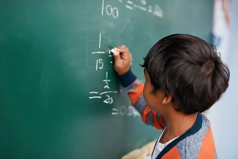Easy as cake. a focussed young elementary school kid writing answers to math Stock Photos