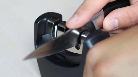 Easy close-up kitchen knife sharpening by special three-steps knife sharpener Stock Footage 111077283