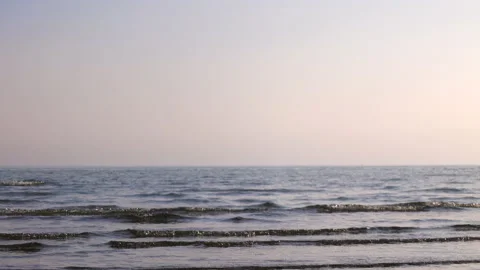 Easy going ocean waves on sand beach at sunset Stock Footage 233993740