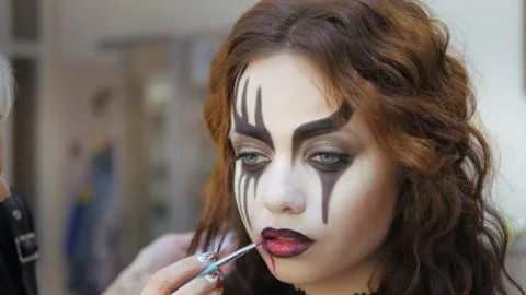 Easy Halloween Makeup. Applying makeup to the face. Applying red paint on the Stock Photos