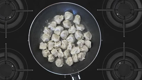 Easy to make lunch or dinner. Meat dumplings in a pan, cooking process in the Stock Footage 148723639