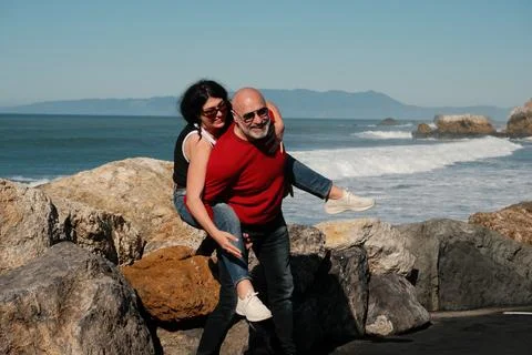 Easygoing Couple Dressed In Denim Experiencing Happiness Near Ocean Waves Stock Photos