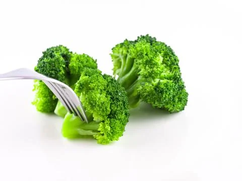 Eat broccoli with a fork, Broccoli is cooked on white background isolate, Ste Stock Photos