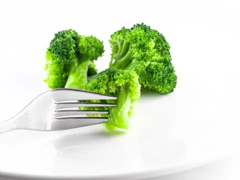 Eat broccoli with a fork, Broccoli is cooked on white background isolate, Ste Stock Photos
