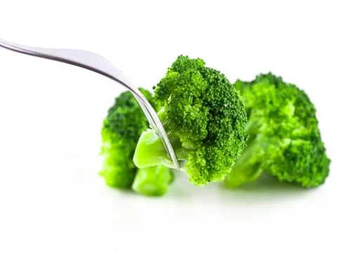 Eat broccoli with a fork, Broccoli is cooked on white background isolate, Ste Stock Photos