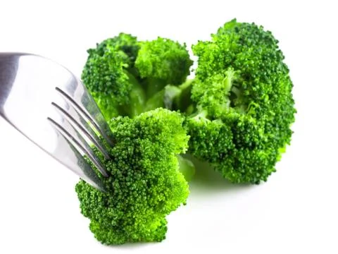 Eat broccoli with a fork, Broccoli is cooked on white background isolate, Ste Stock Photos